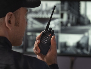 portrait male security guard with radio station camera screens min